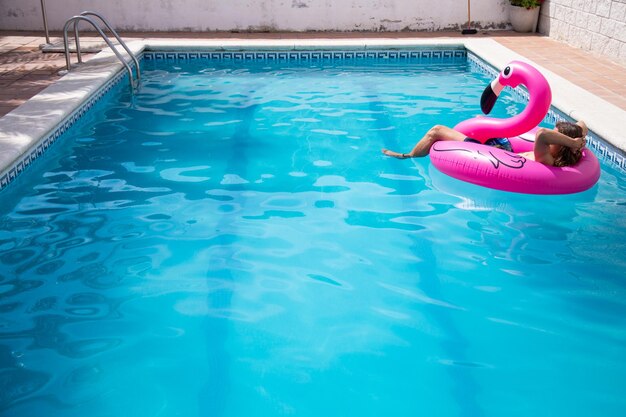 Hombre relajándose en una balsa inflable en una piscina