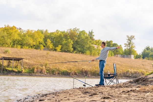 Hombre relajante y pescando junto al lago