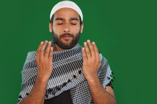 Hombre religioso musulmán indio rezando sobre fondo de pantalla verde