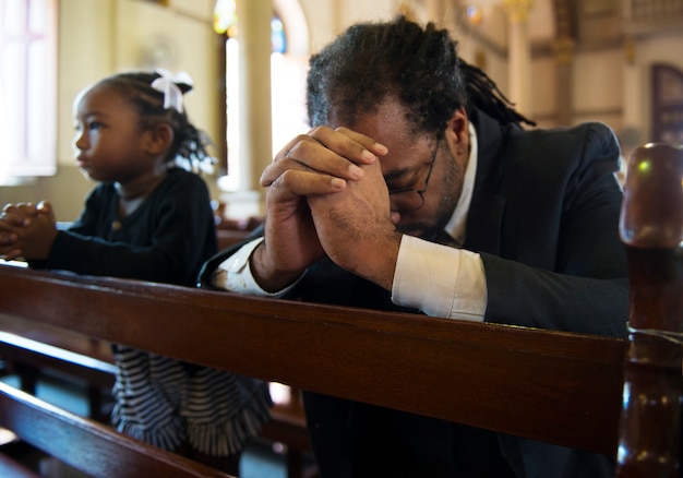 Hombre religioso orando dentro de una iglesia