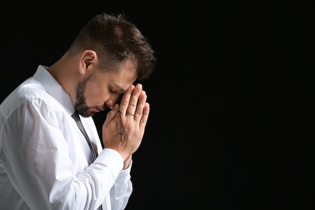 Hombre religioso rezando en la oscuridad