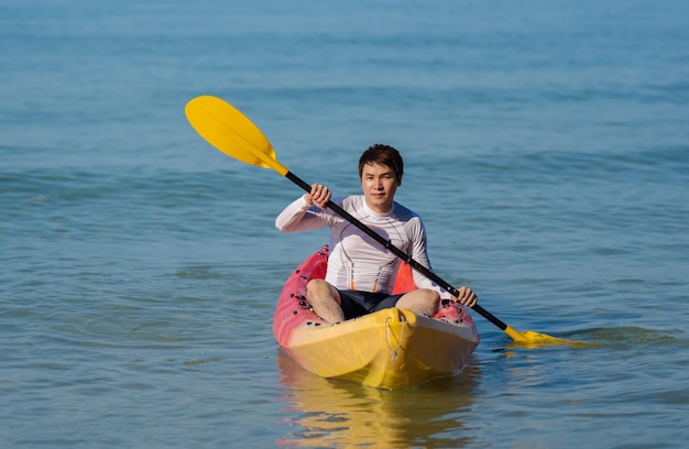 Hombre remando un bote de kayak en el mar