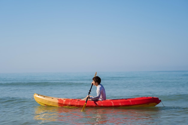 Hombre remando un bote de kayak en el mar