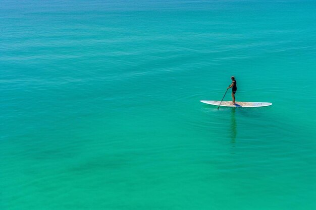 Foto un hombre está remando en una tabla de surf en el agua