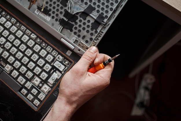 El hombre repara la computadora portátil por sí mismo reparación de computadoras