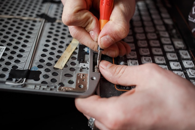 El hombre repara la computadora portátil por sí mismo reparación de computadoras