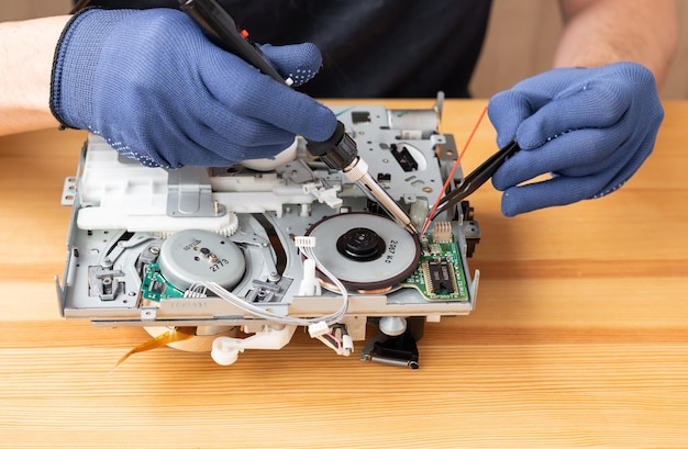 Foto un hombre repara y suelda microcircuitos para electrodomésticos