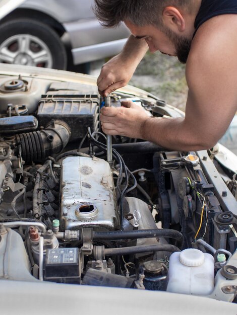 Hombre reparando motor 4g13 en una calle en garaje