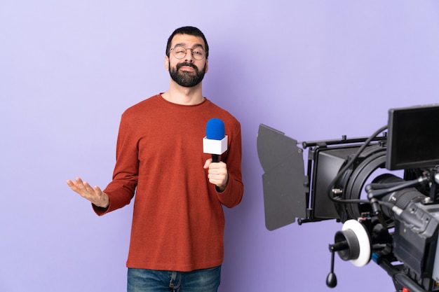 Hombre reportero posando sosteniendo un micrófono