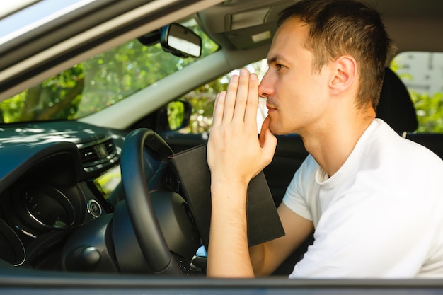 el hombre reza con una biblia en un auto