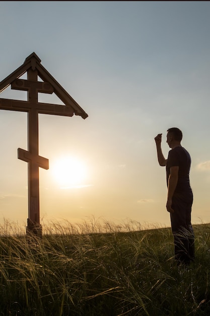 hombre rezando al aire libre al atardecer concepto cristiano
