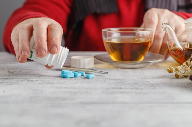 Hombre con rheum sosteniendo una taza de té caliente