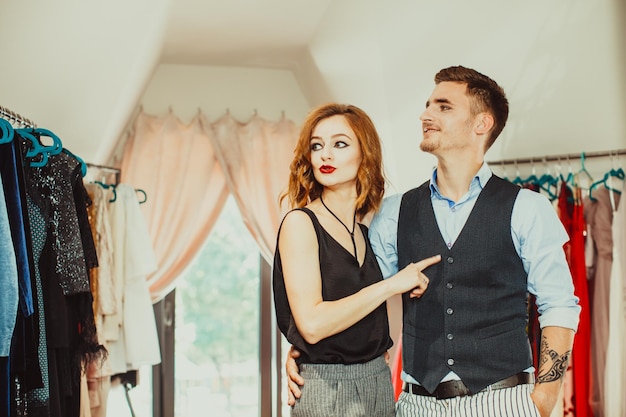 Hombre rico en la tienda de vestidos de moda de belleza con su mujer