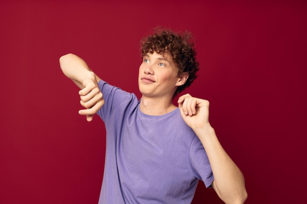 Hombre rizado en una camiseta sobre un fondo de color posando