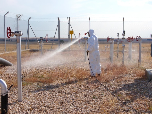 Hombre rociando agua en el campo contra el cielo