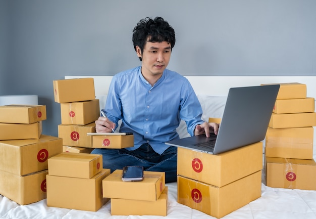 hombre rodeado de cajas usando una laptop