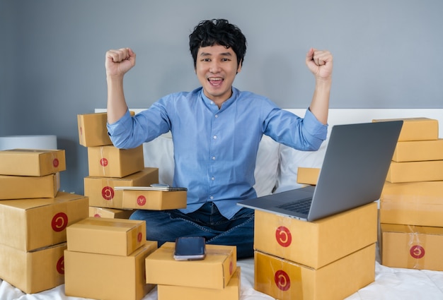 hombre rodeado de cajas usando una laptop