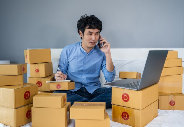 hombre rodeado de cajas usando una laptop