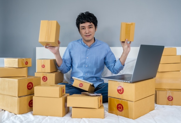 hombre rodeado de cajas usando una laptop