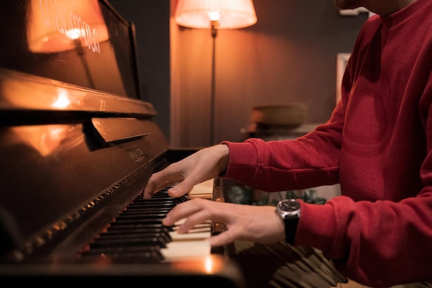 Un hombre de rojo toca el piano.