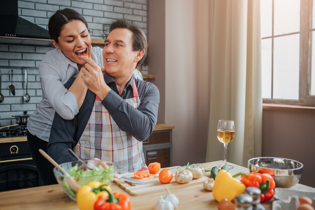 Hombre romántico alimentando a mujer con trozo de verdura