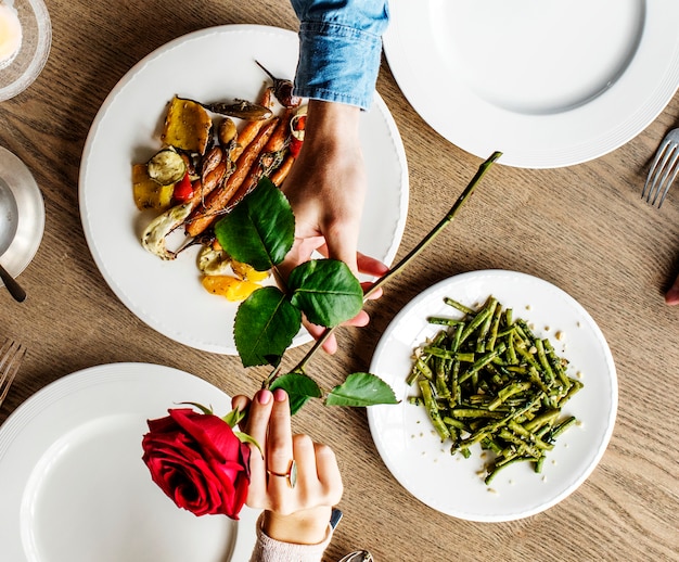 Hombre romántico dando una rosa a la mujer en una cita