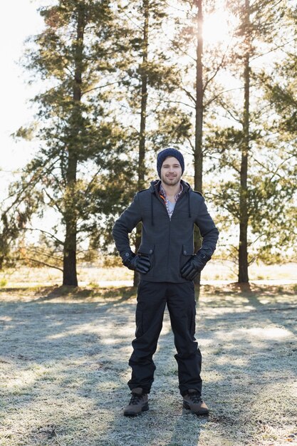 Hombre en ropa de abrigo dando un paseo en el bosque en un día de invierno