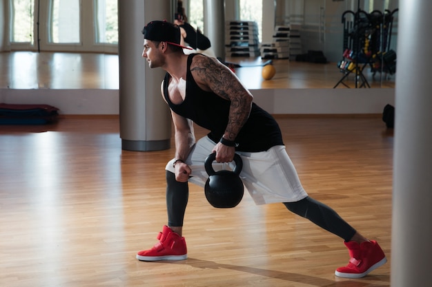 hombre en ropa deportiva está entrenando en el gimnasio