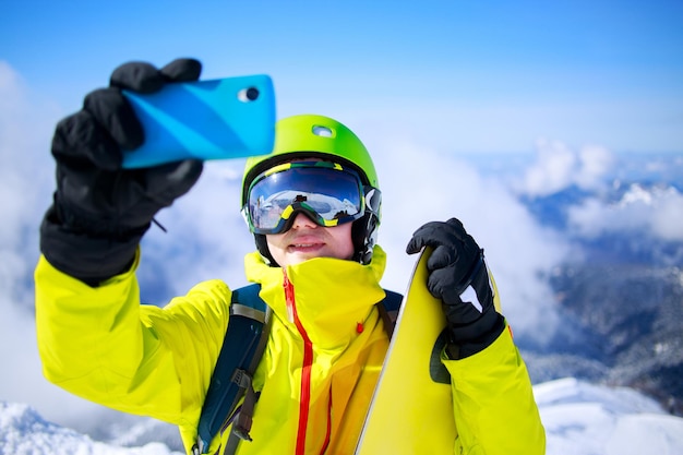 Foto hombre en ropa de invierno tomando un selfie con esquís