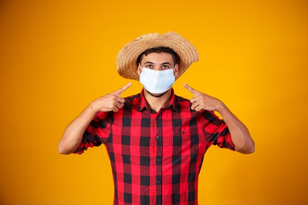 Hombre con ropa típica de la famosa fiesta brasileña llamada "Festa Junina" en celebración con máscara para la prevención del covid