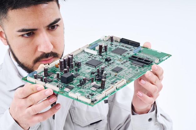 Un hombre en ropa de trabajo con una placa de computadora.