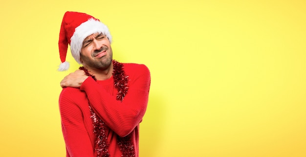 Hombre con ropas rojas celebrando las fiestas navideñas sufriendo de dolor en hombro