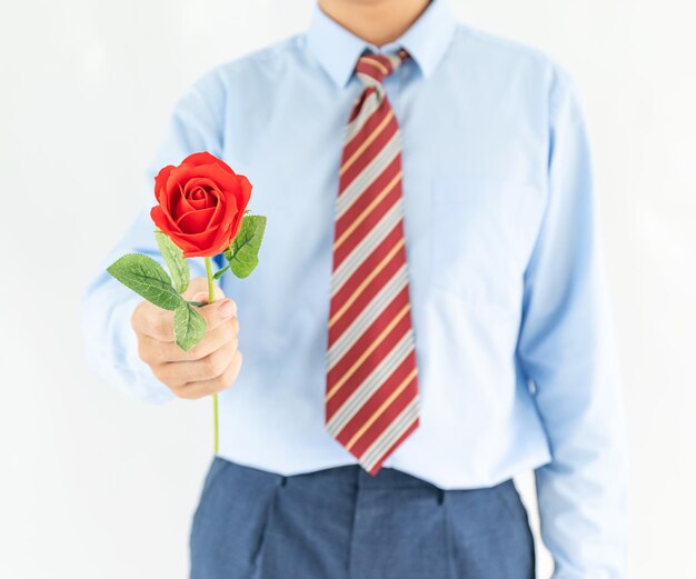 Hombre con una rosa roja sobre un fondo blanco