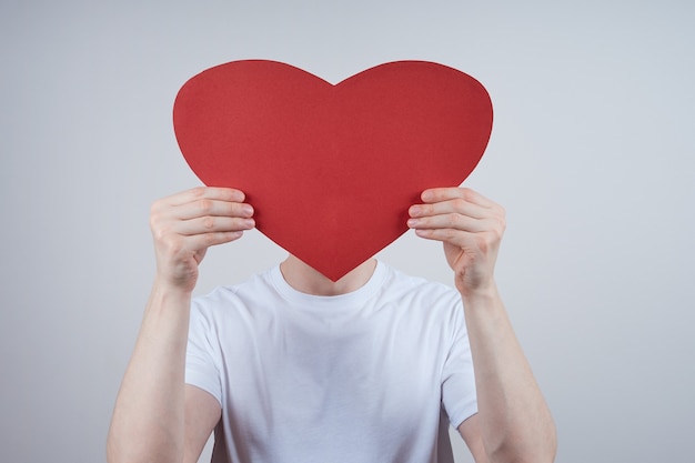 Un hombre sin rostro, un rostro cubierto con un corazón de papel