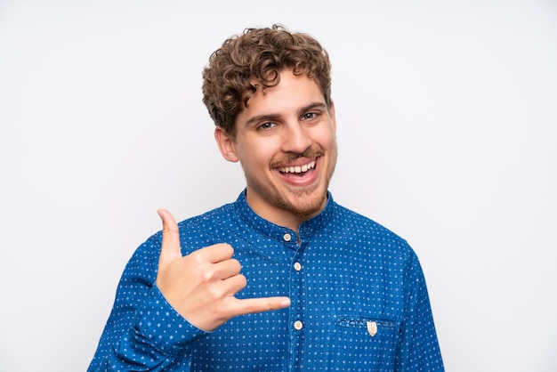 Hombre rubio con camisa azul haciendo gesto de teléfono