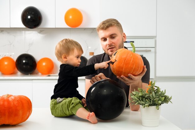 hombre rubio caucásico mostrar calabaza a niño feliz día de halloween