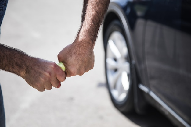 Un hombre saca un trapo cerca del auto.