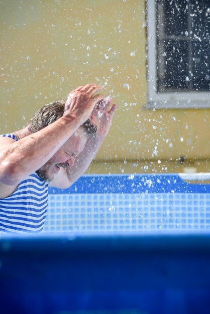 Hombre con salpicaduras de agua en la piscina