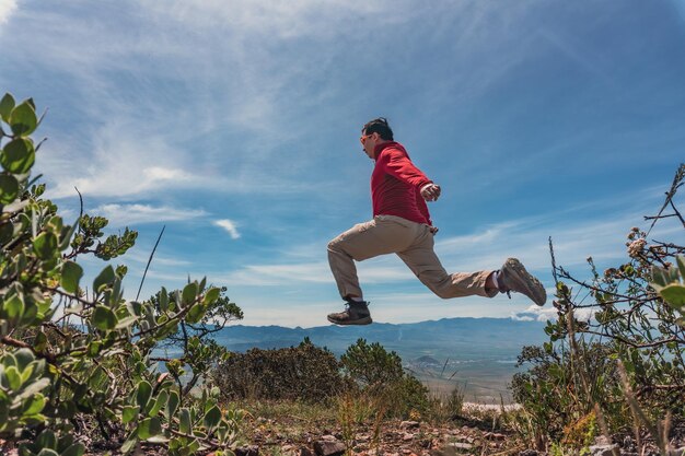 Hombre saltando por encima de las rocas en la montaña