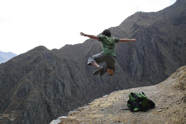 Foto hombre saltando en la montaña