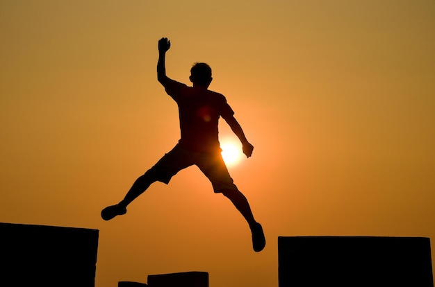 Hombre saltando silueta sobre fondo puesta de sol