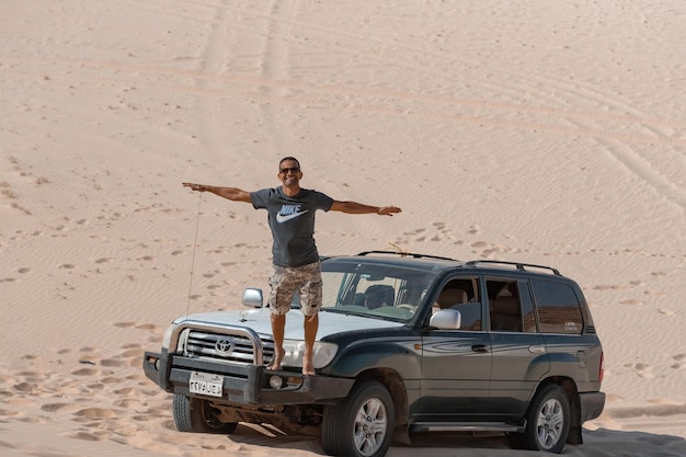 Foto hombre saltando de su camión todoterreno en el desierto de sinaí egipto