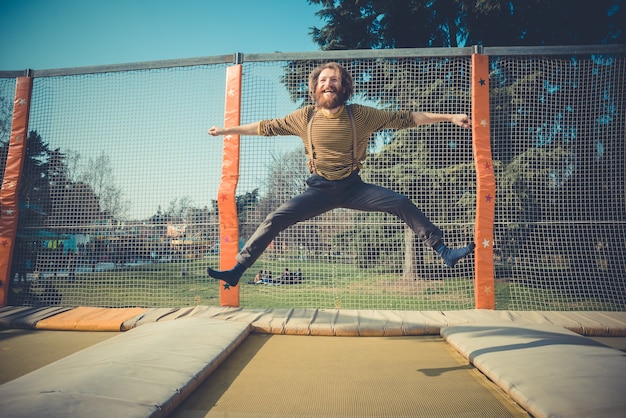 hombre saltando en trampolín en el patio de recreo