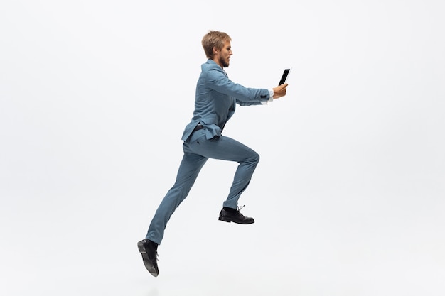 Hombre de salto ganador en ropa de oficina corriendo trotar sobre fondo blanco como atleta profesional