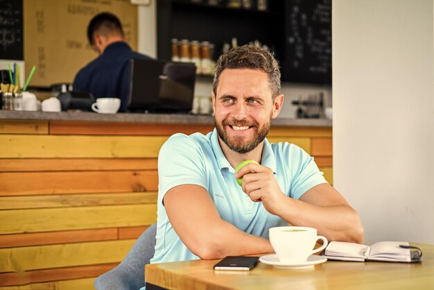 Hombre saludable cuidado vitamina nutrición durante la jornada laboral bocadillo saludable concepto de bienestar físico y mental hombre sentado comer manzana verde fruta café y fruta recargar reserva de energía hábitos saludables