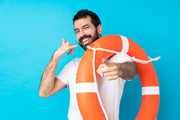 Hombre salvavidas haciendo gesto de teléfono y apuntando al frente