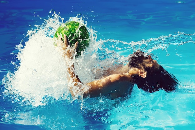 Hombre con sandía en piscina