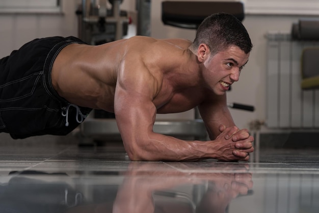 Foto hombre sano haciendo ejercicio abdominal en el piso