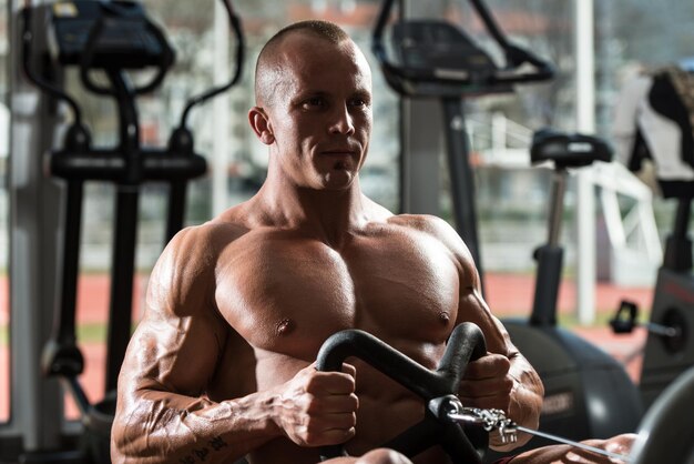 Foto hombre sano haciendo ejercicios de espalda en el gimnasio.