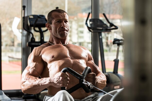 Hombre sano haciendo ejercicios de espalda en el gimnasio.